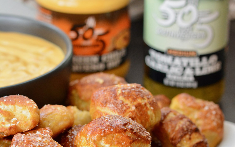 Using our Tomatillo Garlic & Lime Salsa instead of water adds a bit of kick and a ton of flavor to these homemade soft pretzels! Dip the pretzel bites in our Green Chile Queso for the ultimate snack! They feed a crowd and can be made ahead and reheated. Thanks to our friends at The Oven Light for creating this delicious treat!