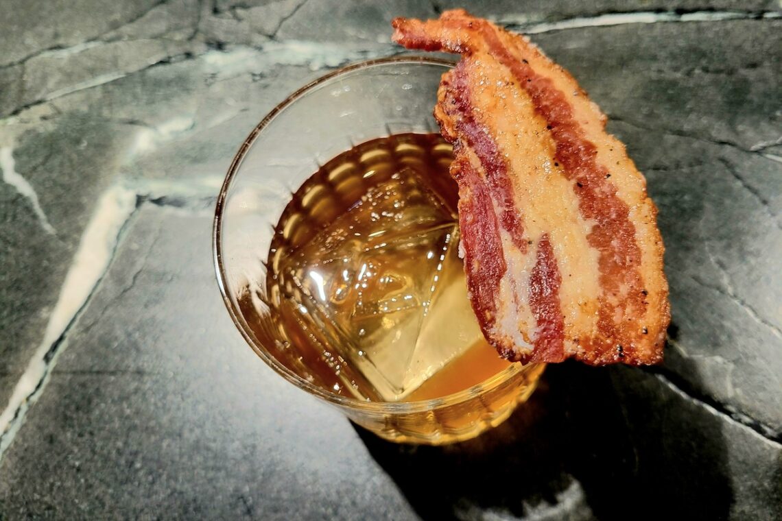 marble table with cocktail on it and bacon