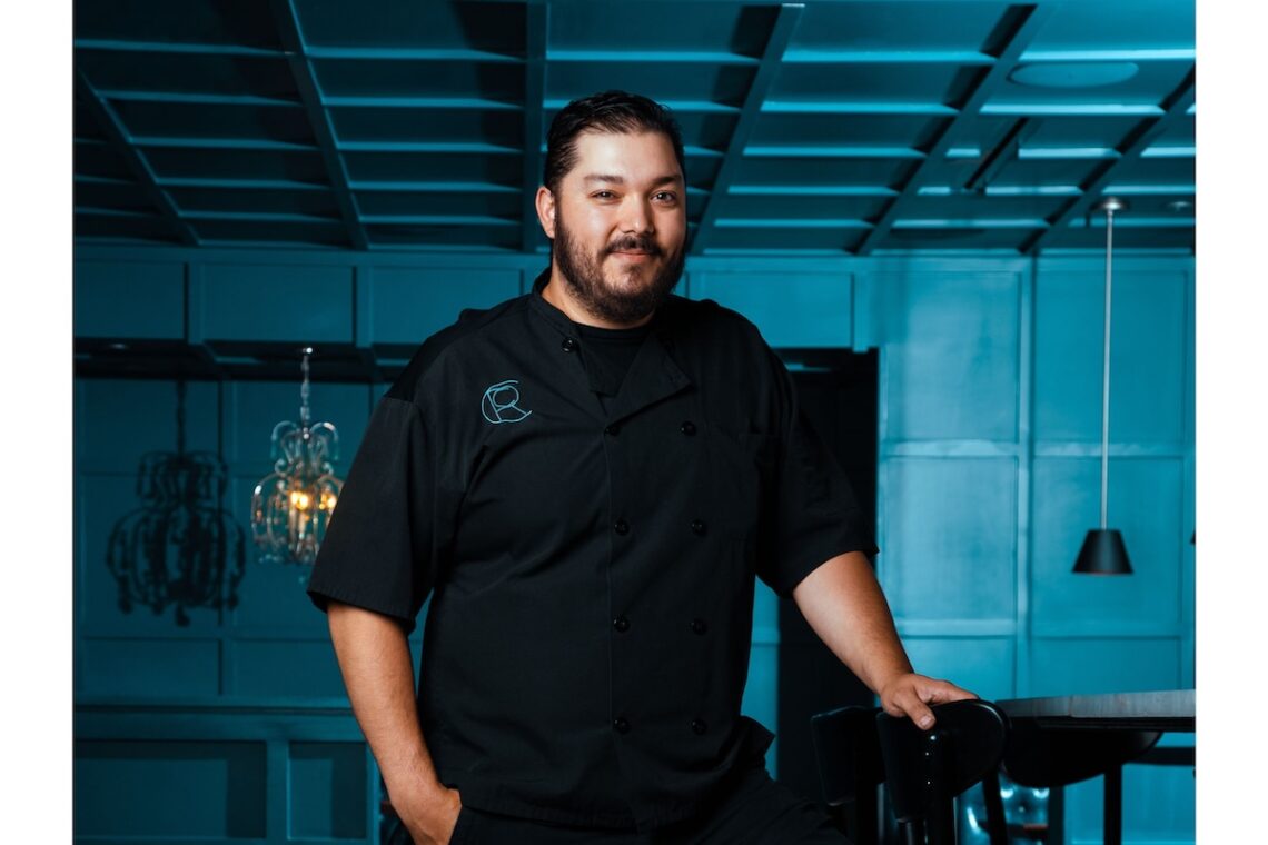 blue room with latino man in black chef clothes