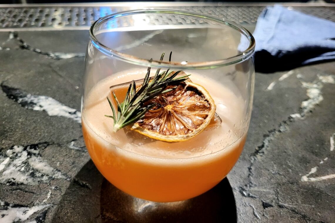 orange cocktail in glass on marbled table