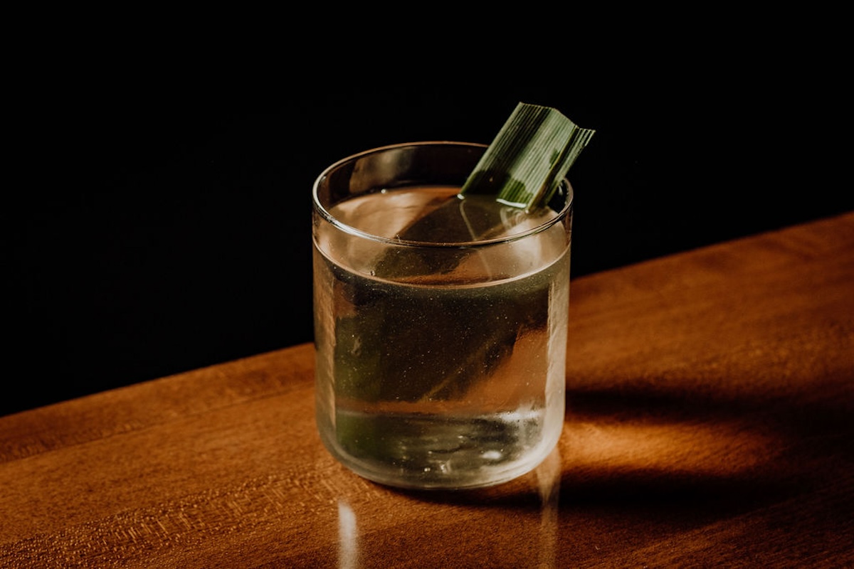 dark bar with clear cocktail on wood table