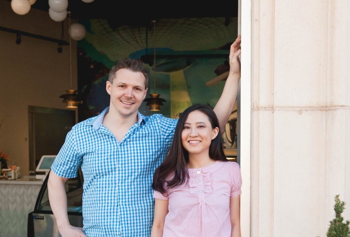 white man and asian woman standing in door way