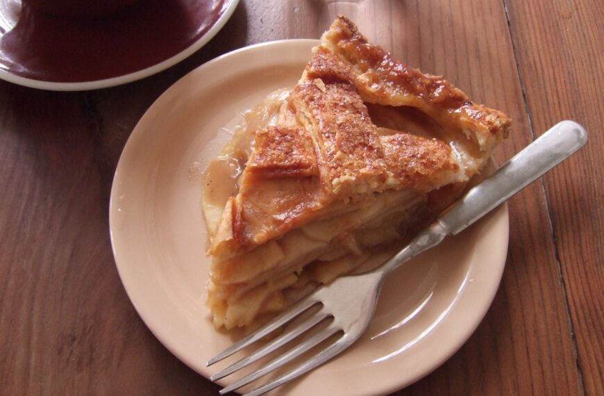 slice of apple pie on white plate with fork