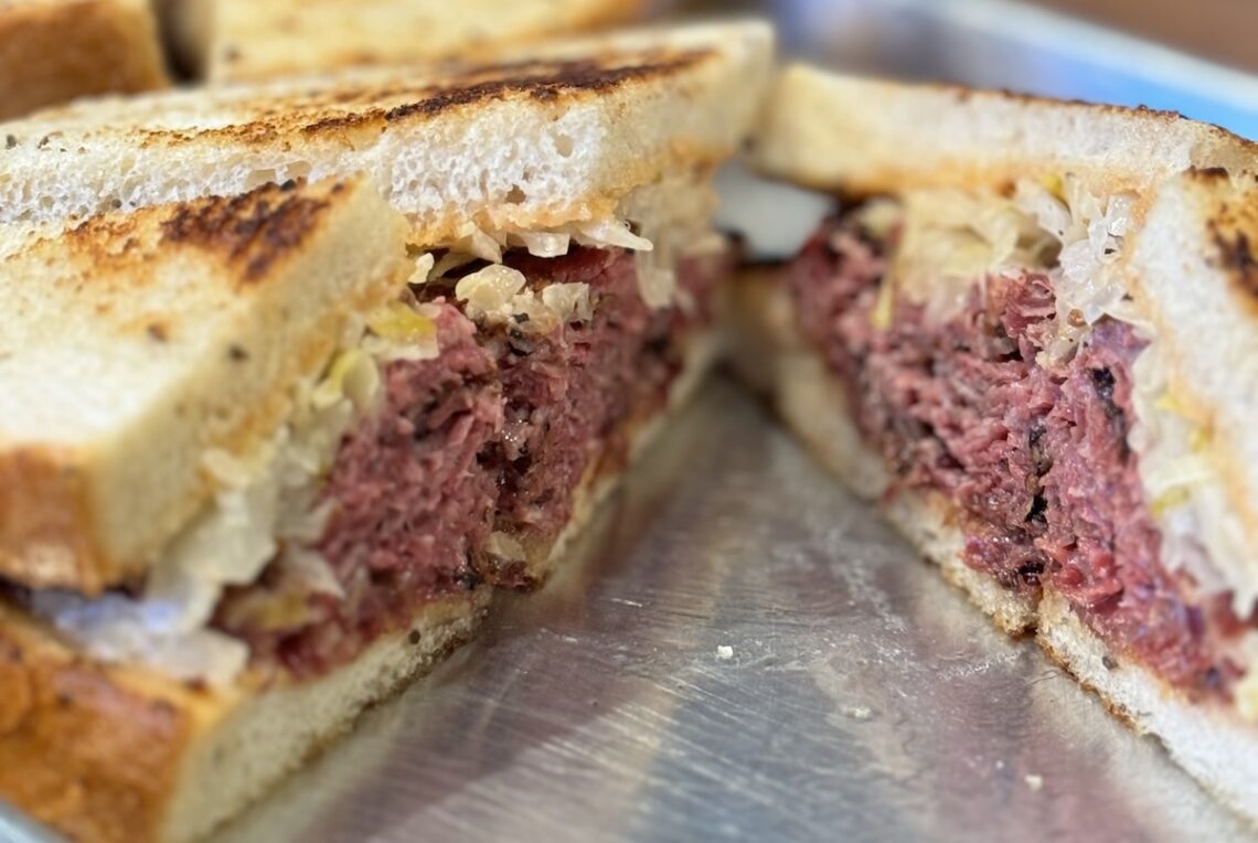 marbled rye bread with corned beef in a sandwich on a metal plate