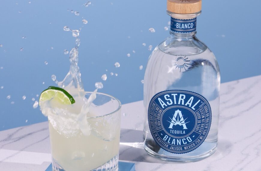 blue background with bottle of astral tequila and margarita