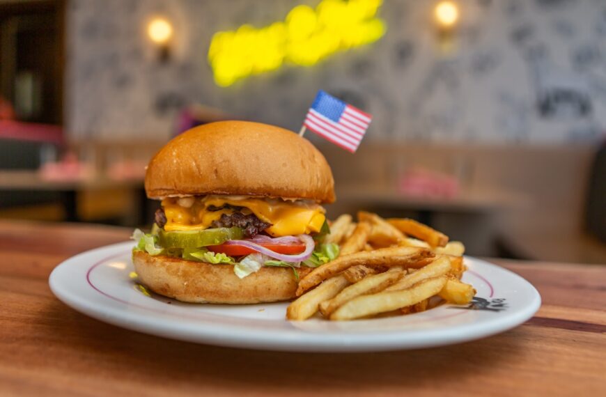 wood table with burger and fries and flag