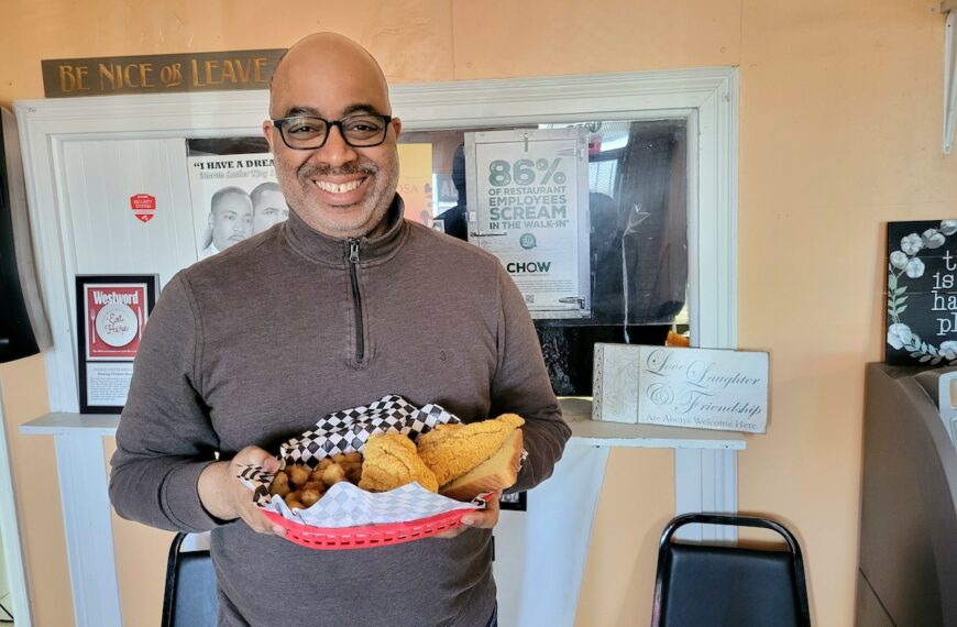 black man holding a basket of fried food