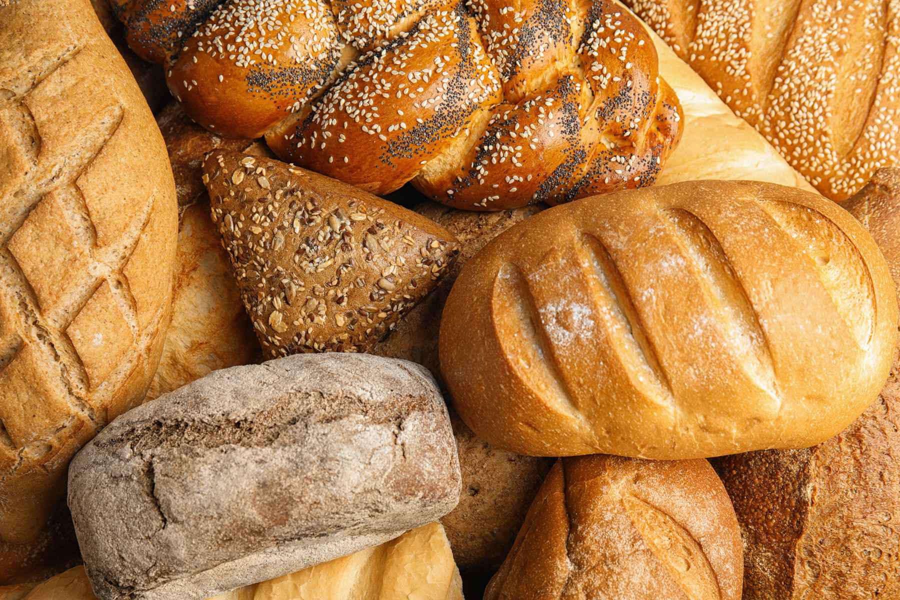 Assortment of loves of bread with different patterns slashed into the crusts.