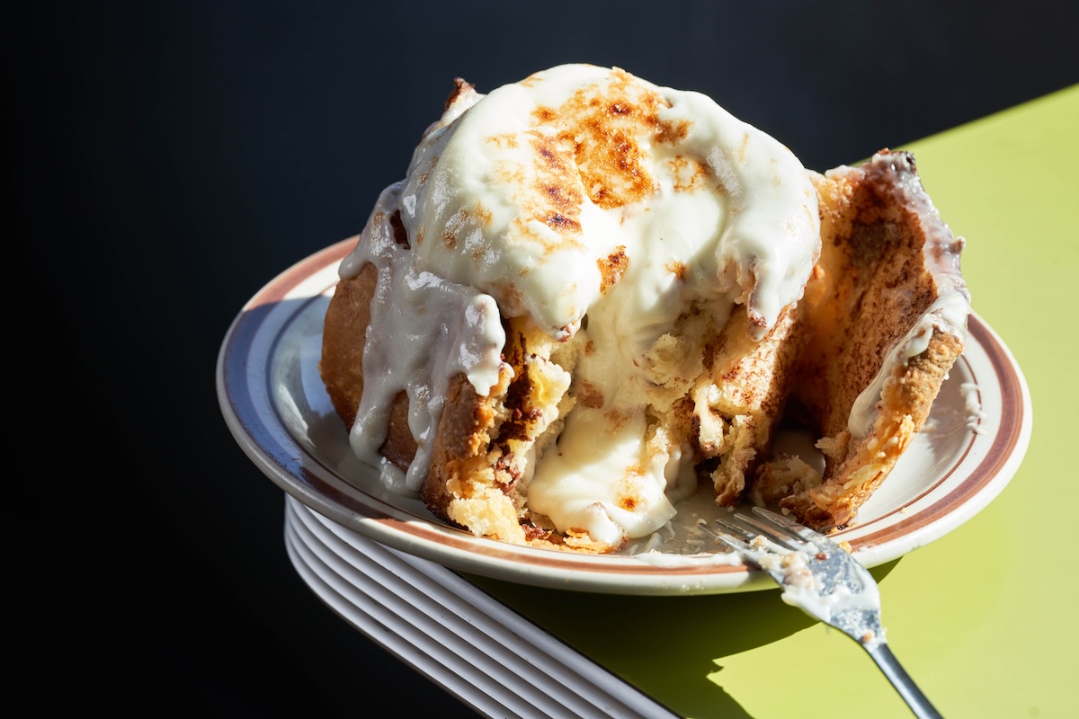 cinnamon roll being eaten with fork