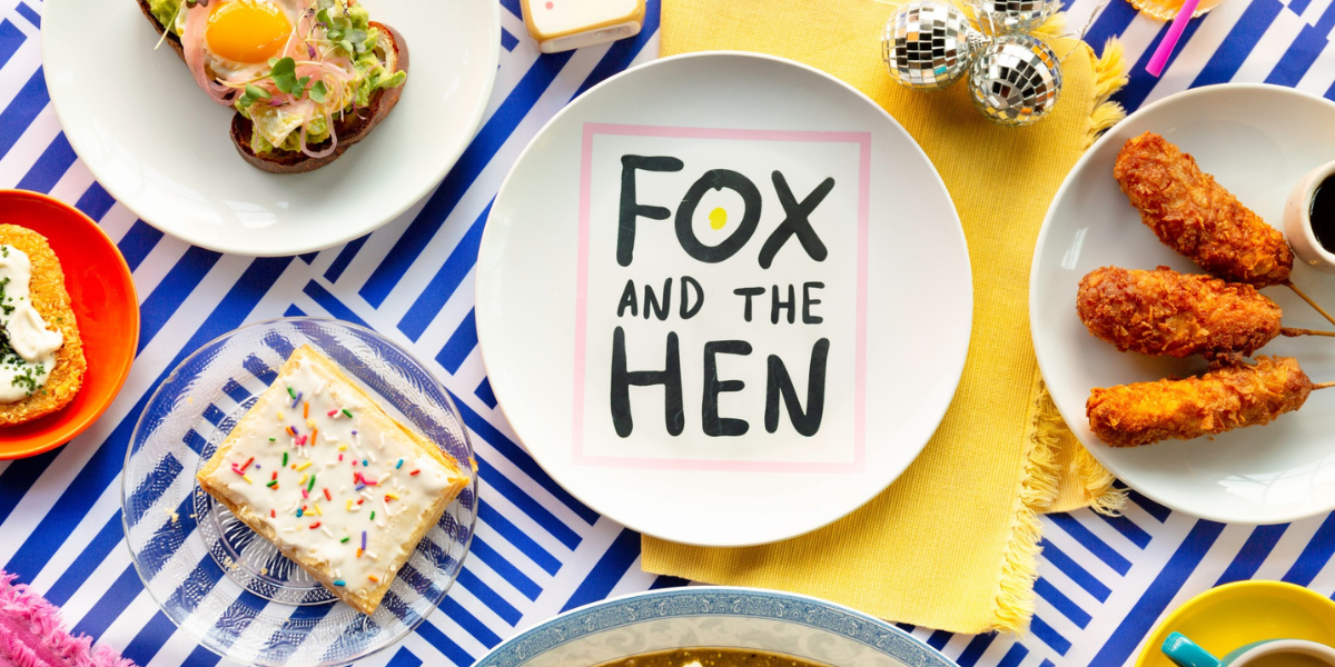 There’s so much to love about Fox and the Hen, the new all-day breakfast joint by Carrie Baird—and then there’s the stuff I am obsessed with already. It’s fun, it’s playful, it’s got wallpaper I want to steal and design details I want to copy. Its color palette is perfect. I want the wallpaper. Need it. Want to put my TV in a frame surrounded by it just like they did at the Fox and the Hen. I want a hot sauce wall, too. I want a neon sign glowing against a minimalist wallpapered wall with custom designs. And I want everyone to be as delighted as I am to see a comma joke on a menu.
