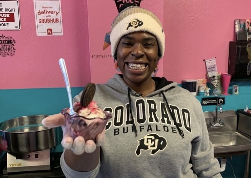 black woman holding ice cream with pink wall