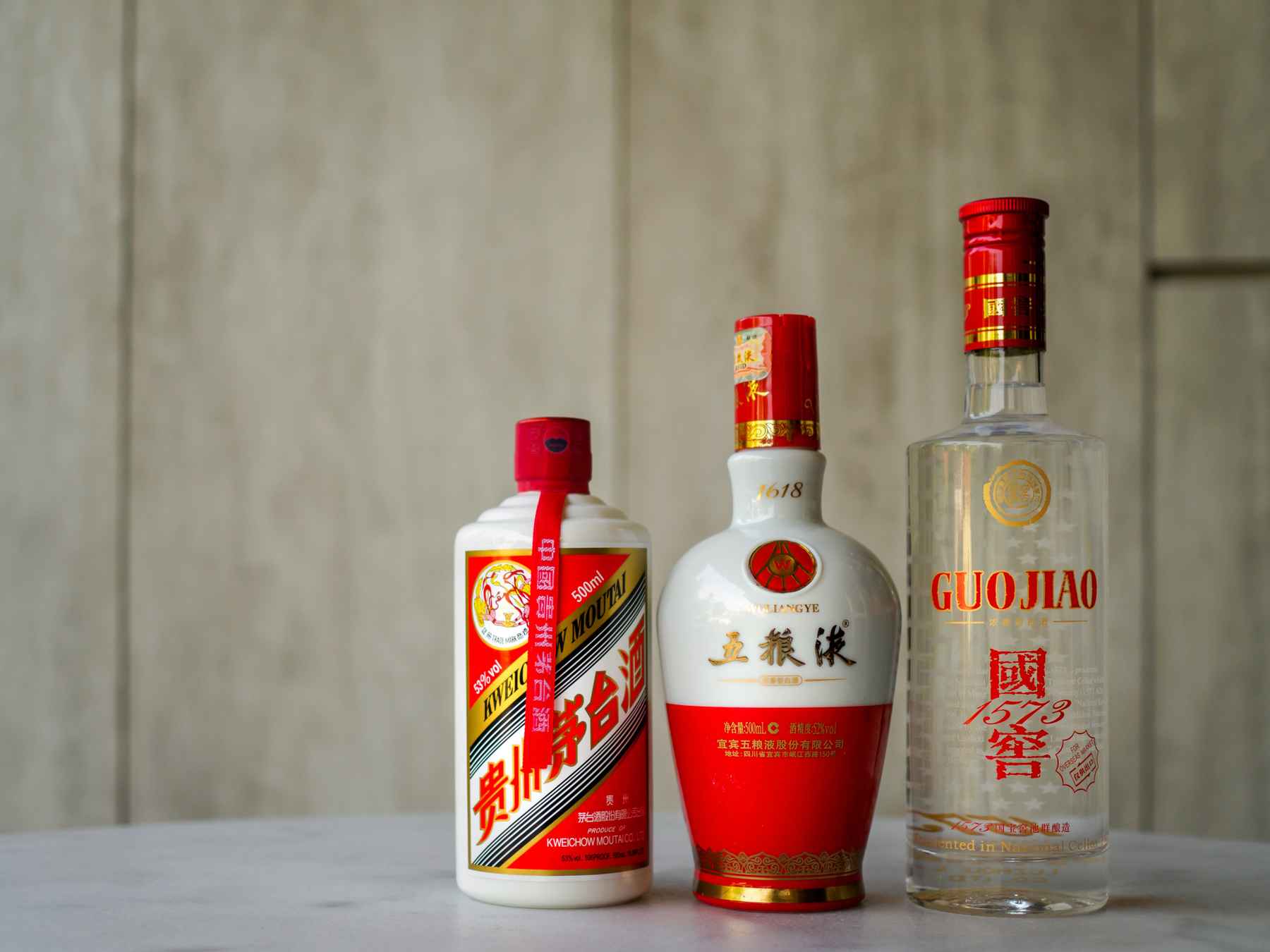 Three different red and white baijiu (Chinese liquor) bottles, arranged from shortest to tallest.