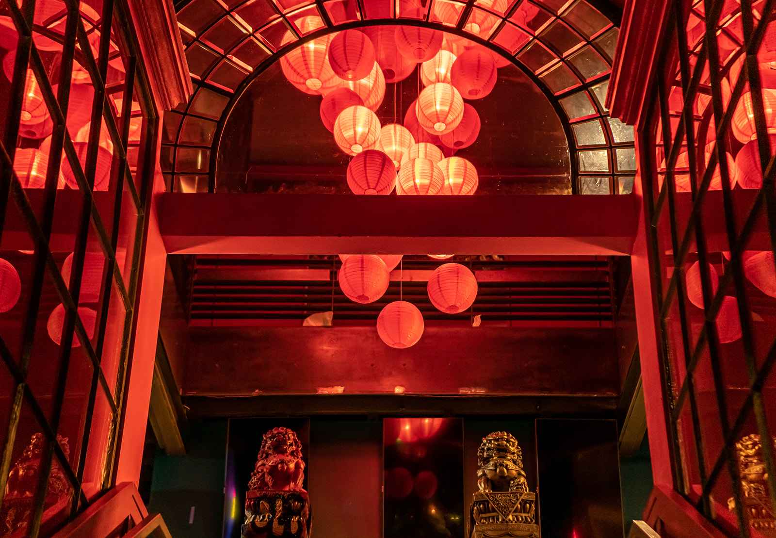 Interior of Bao Brewhouse, which serves baijiu. Two story interior from front door, with gold Chinese lion statues and red paper lanterns.