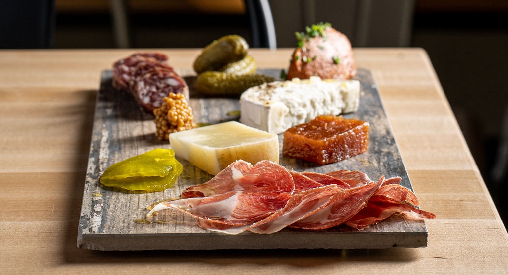 gray board with charcuterie meats and cheeses on it