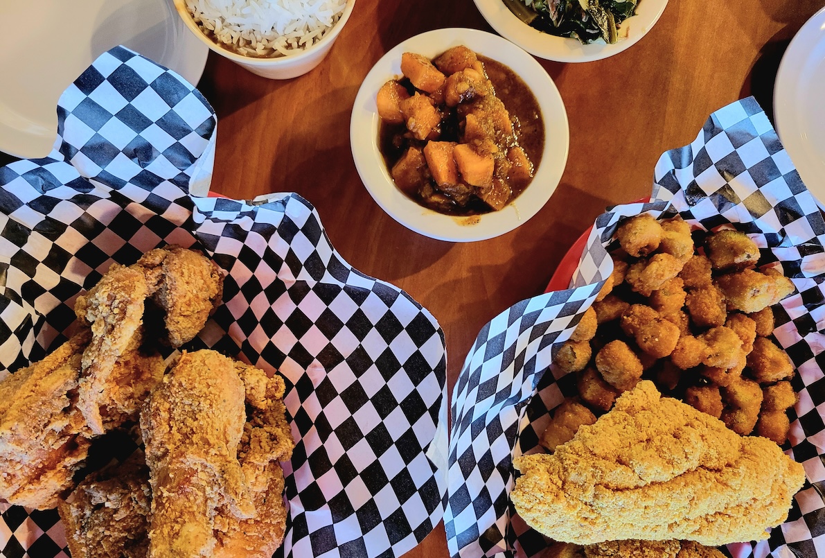 wood table with baskets of fried food on a blue and white checkered paper