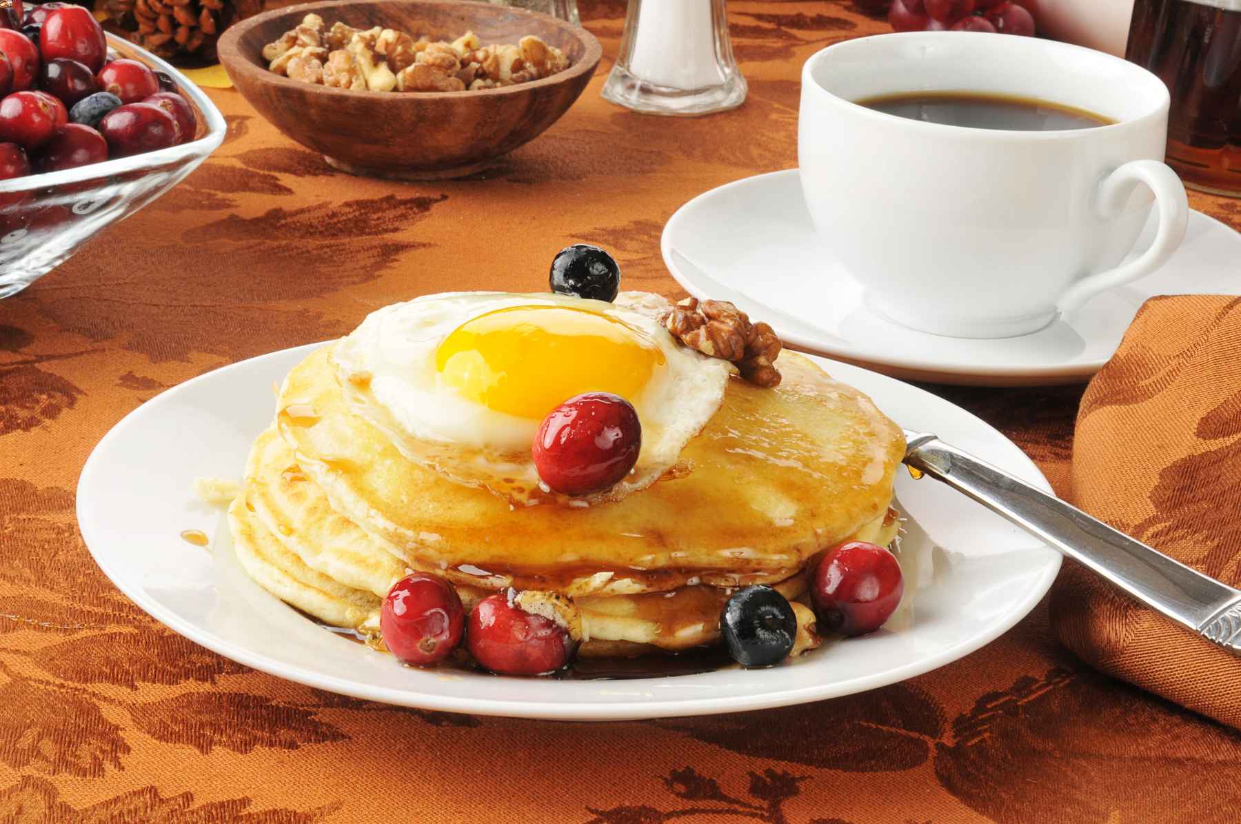 Stack of pancakes with berries and nuts topped with a fried egg. Brunch poll results