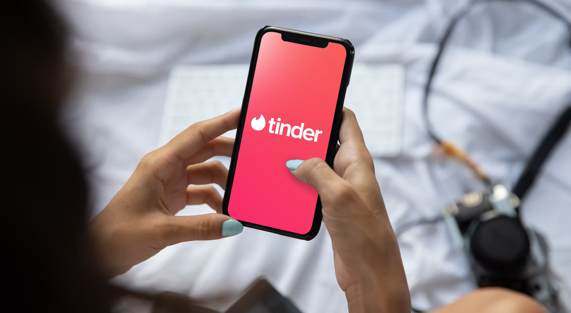 hands using tinder for dating on cell phone
