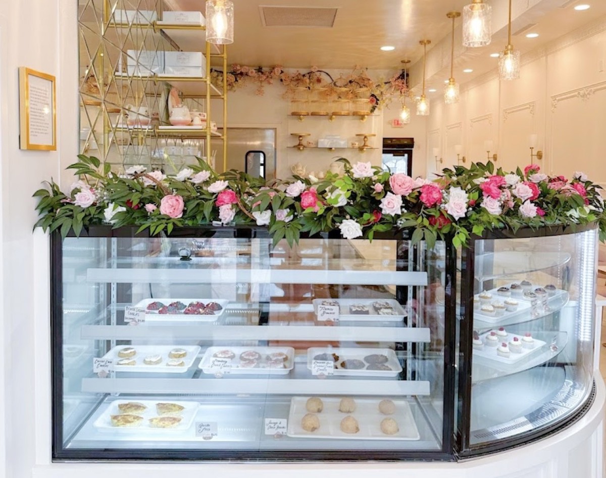 The bakery case, adorned with flowers, at Sweet Gilly's Specialty Bakeshop