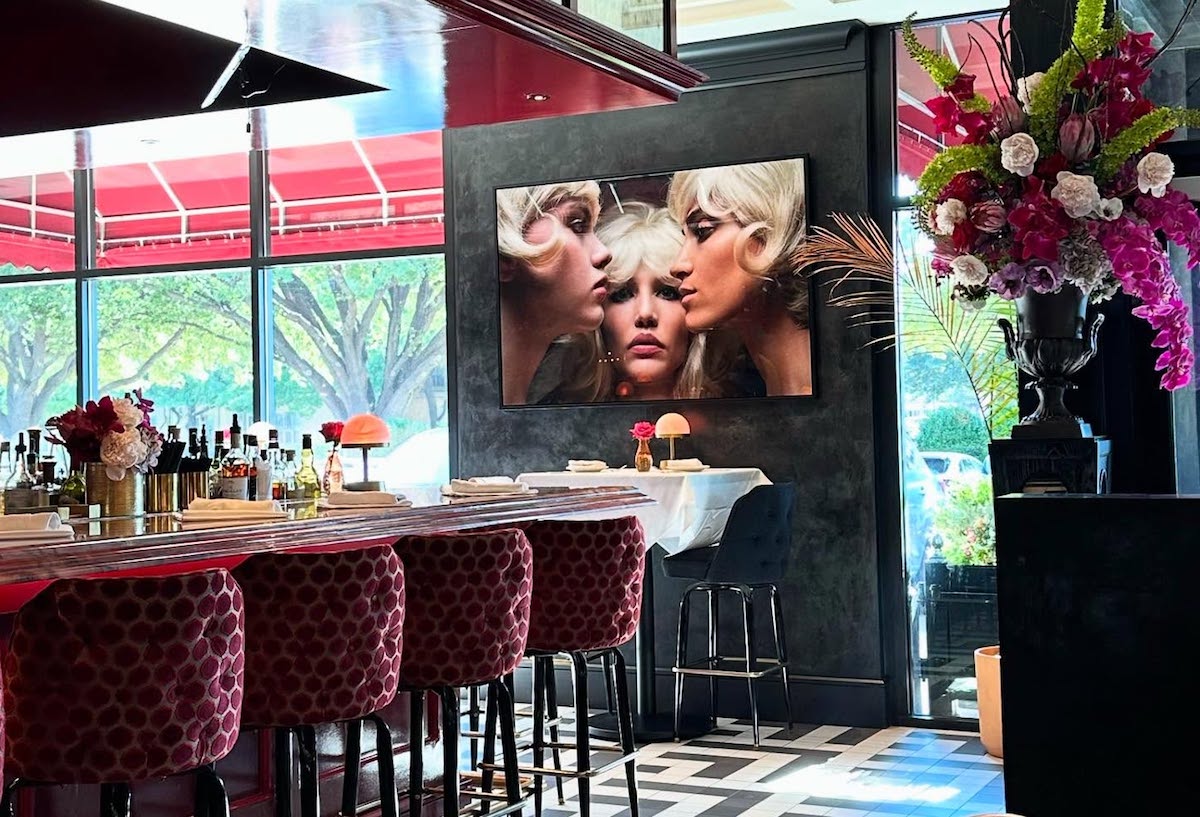 The vibrant bar at Le Margot, decorated with art, plush furnishings, and florals. | Photo by Le Margot