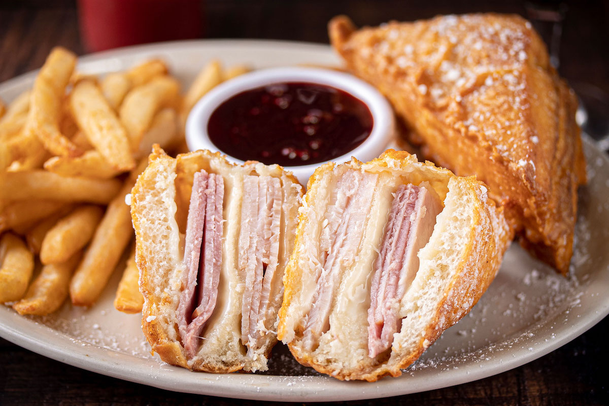 Mel’s Country Cafe puts a Southern spin on the classic Monte Cristo, stuffing ham, turkey, and Swiss cheese into a fried sandwich served with raspberry dipping sauce. | Photo by Mel's Country Cafe