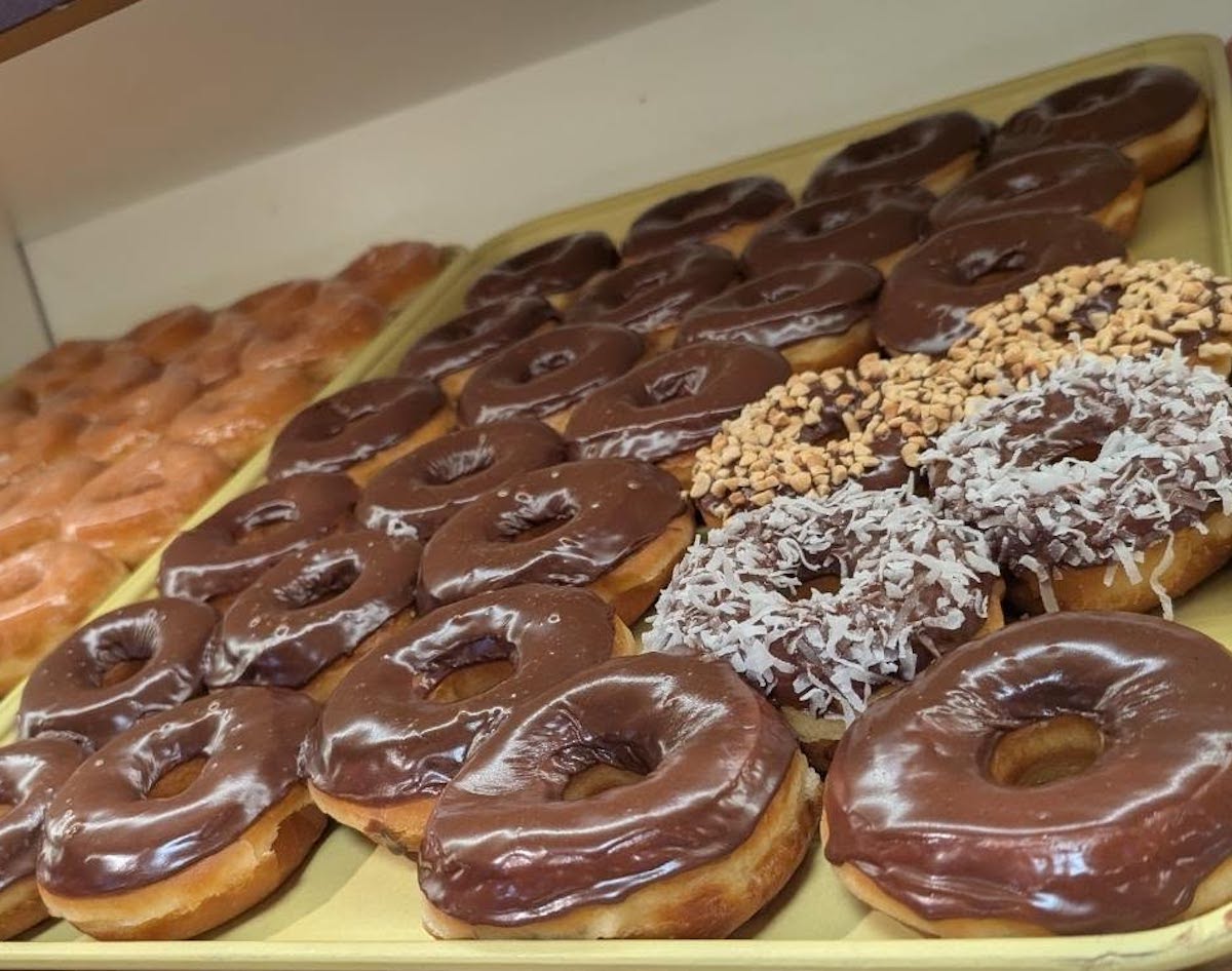 Chocolate-frosted, coconut-topped, and classic glazed doughnuts fill the case at H-Town Donuts. | Photo by H-Town Donuts