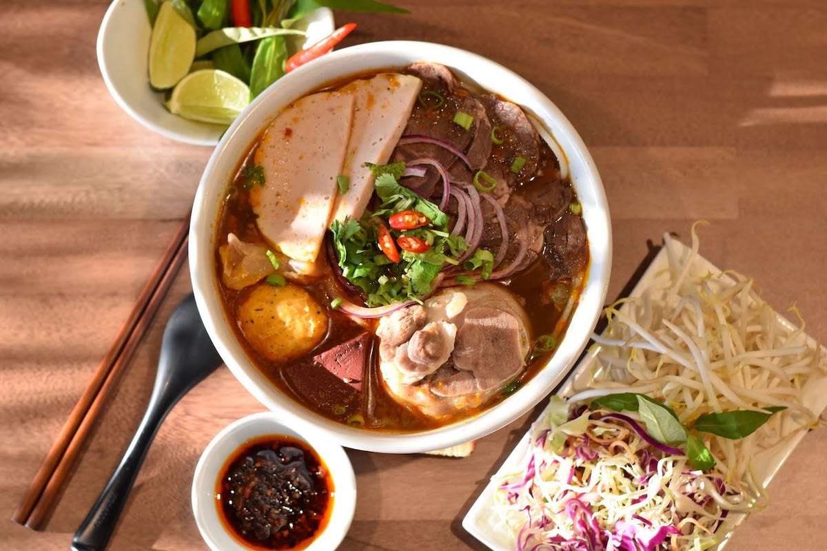 Lua Kitchen's richly spiced bún bò Huế arrives loaded with tender beef, pork, Vietnamese ham, herbs, bean sprouts, and all the traditional accompaniments for customizing every bite. | Photo by Lua Kitchen