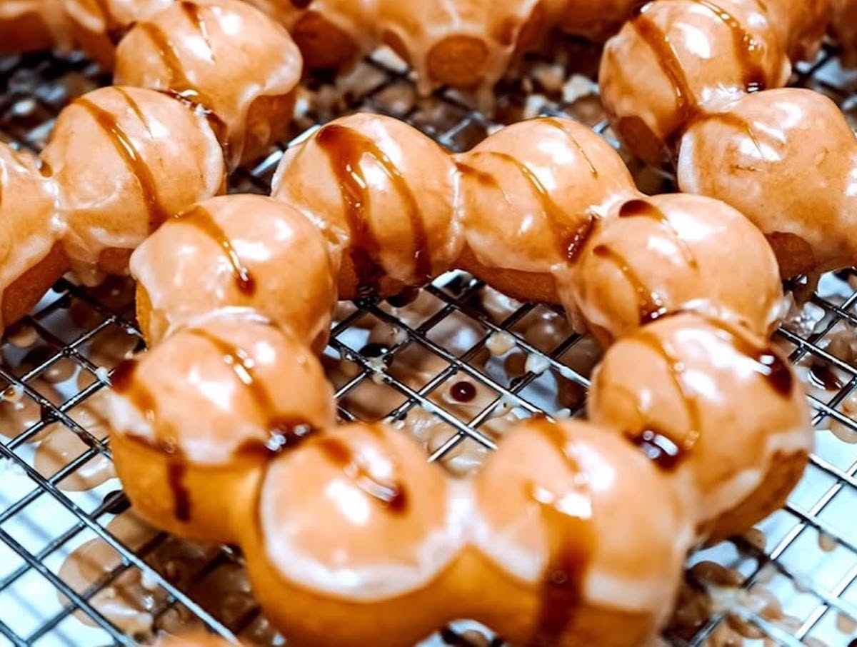 Glossy glazed mochi doughnuts get an extra drizzle at Mochinut. | Photo by Mochinut