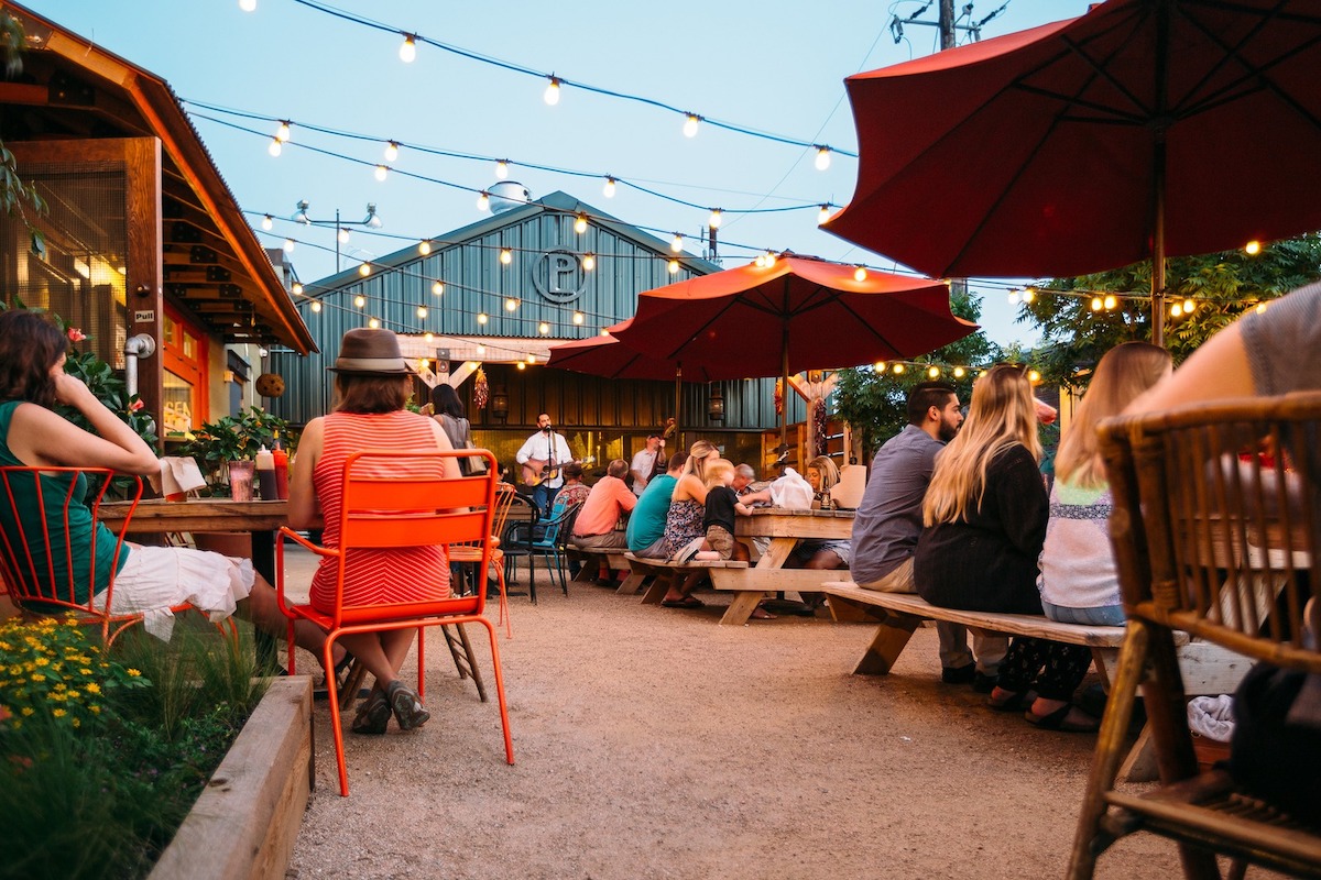 Patrons gather on the patio at Pecan Lodge, one of Deep Ellum’s most iconic restaurants and a cornerstone of Dallas’ historic entertainment district. | Photo by Pecan Lodge