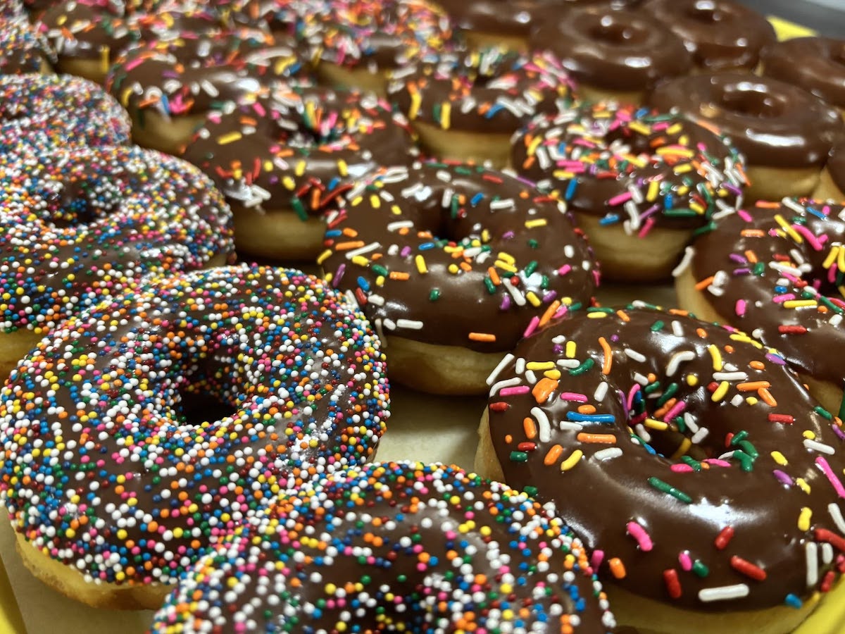 Chocolate-iced doughnut varieties covered in colorful sprinkles at Robin’s Snowflake Donuts & Cafe. | Photo by Robin’s Snowflake Donuts & Cafe