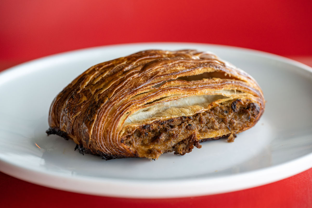 A golden, flaky pastry filled with savory spiced meat at Shakkar, located inside POST Houston's food hall. | Photo by Shakkar