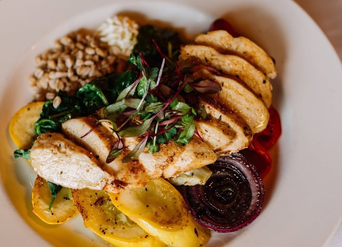 Lonesome Dove - DiningOut Grilled chicken, kale, summer vegetables, goat cheese, farro, jalapeño-basil pesto at Lonesome Dove. | Photo by Lonesome Dove