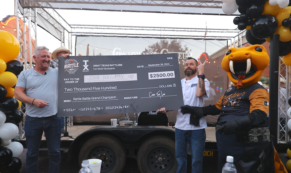 Chef Tim Love takes to the stage to present the prize-winning check during Rattle Battle. | Photo by PBR