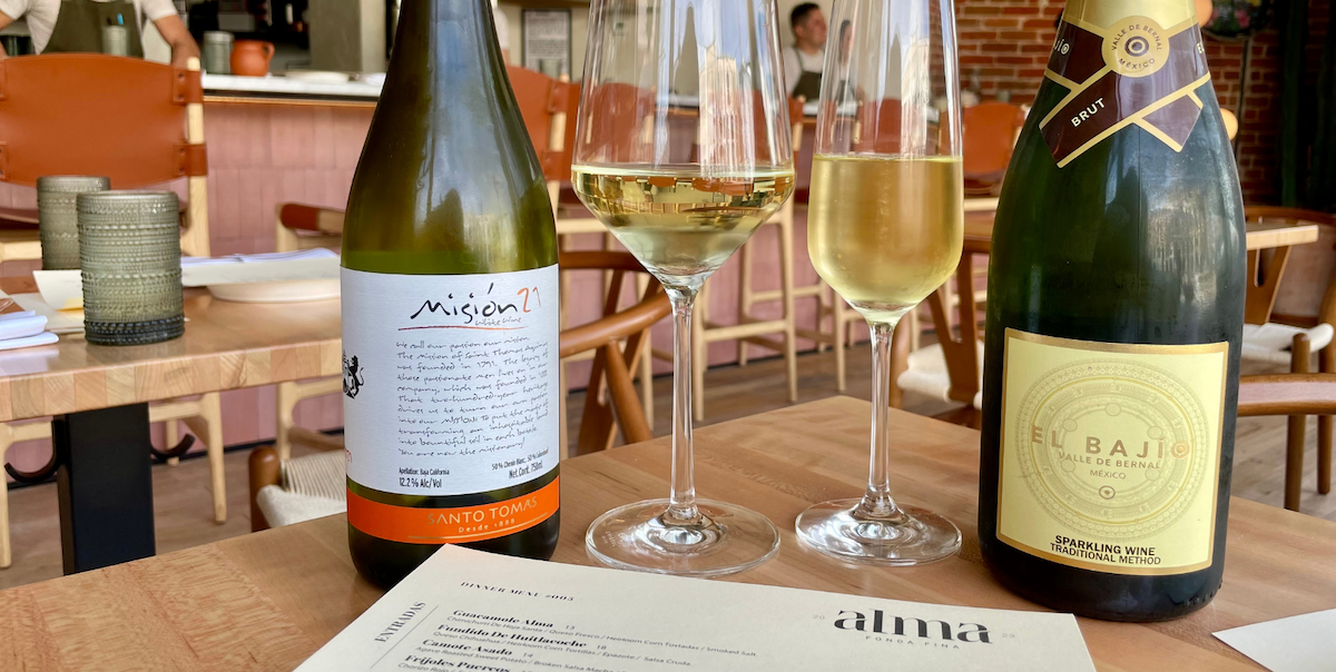 table with two glasses of sparkling white wine and bottle