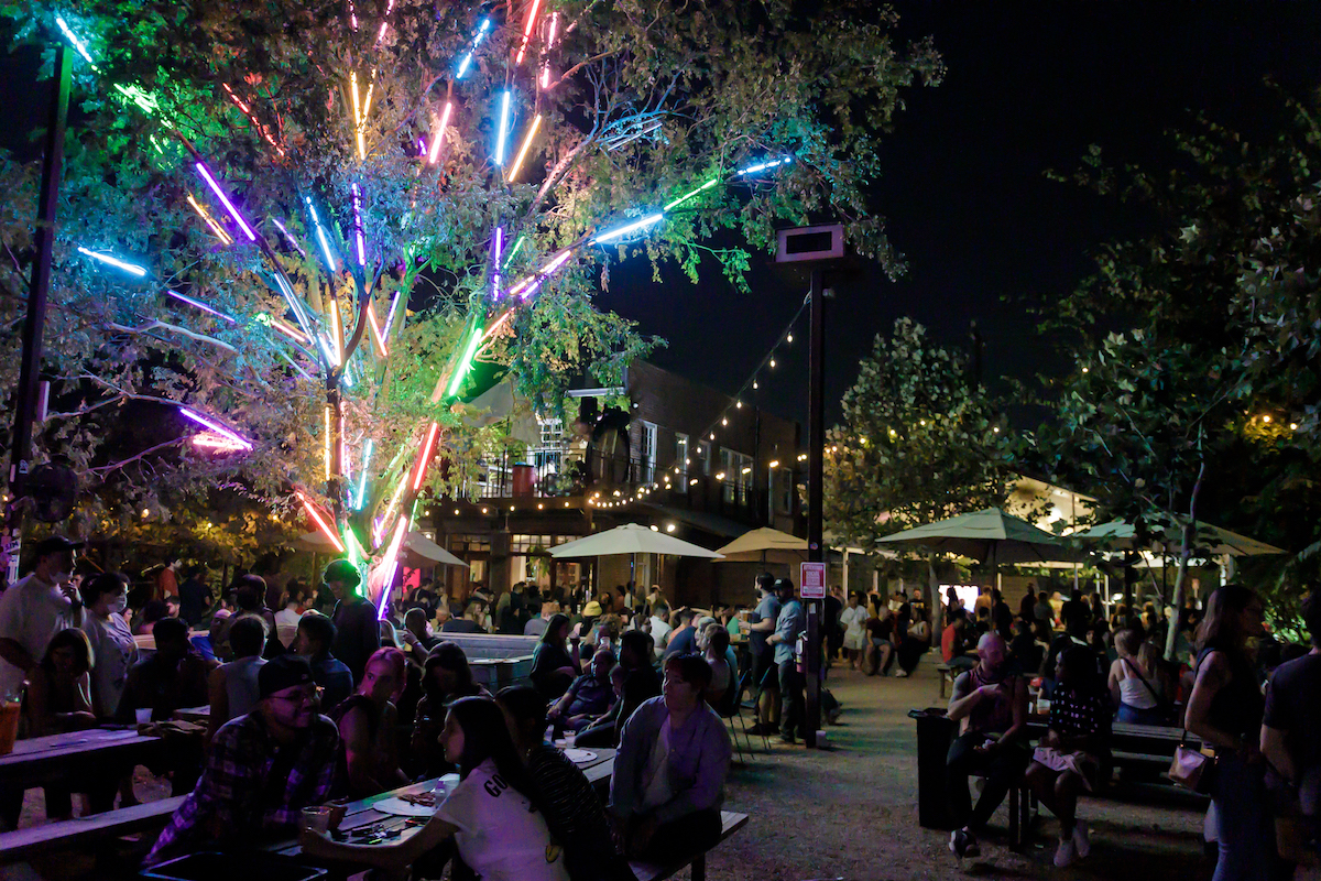 The illuminated tree and crowd on the patio at Axelrad. | Photo by Tommy MIddleton