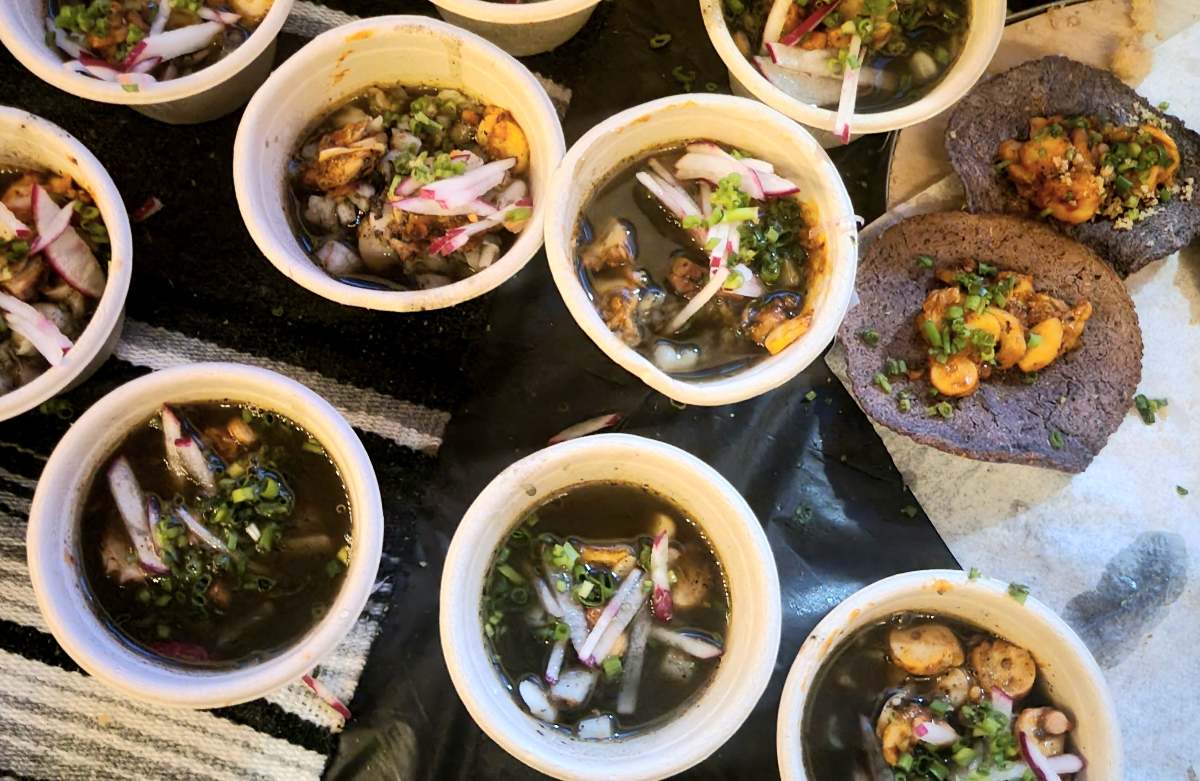 table with bowls of negro pozole on it