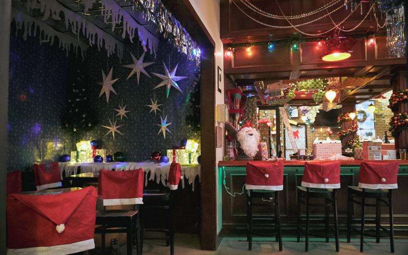 - DiningOut A Christmas-themed bar with Santa hat decorations on the barstools and chairs at Call to Arms Brewing in Denver, Colorado