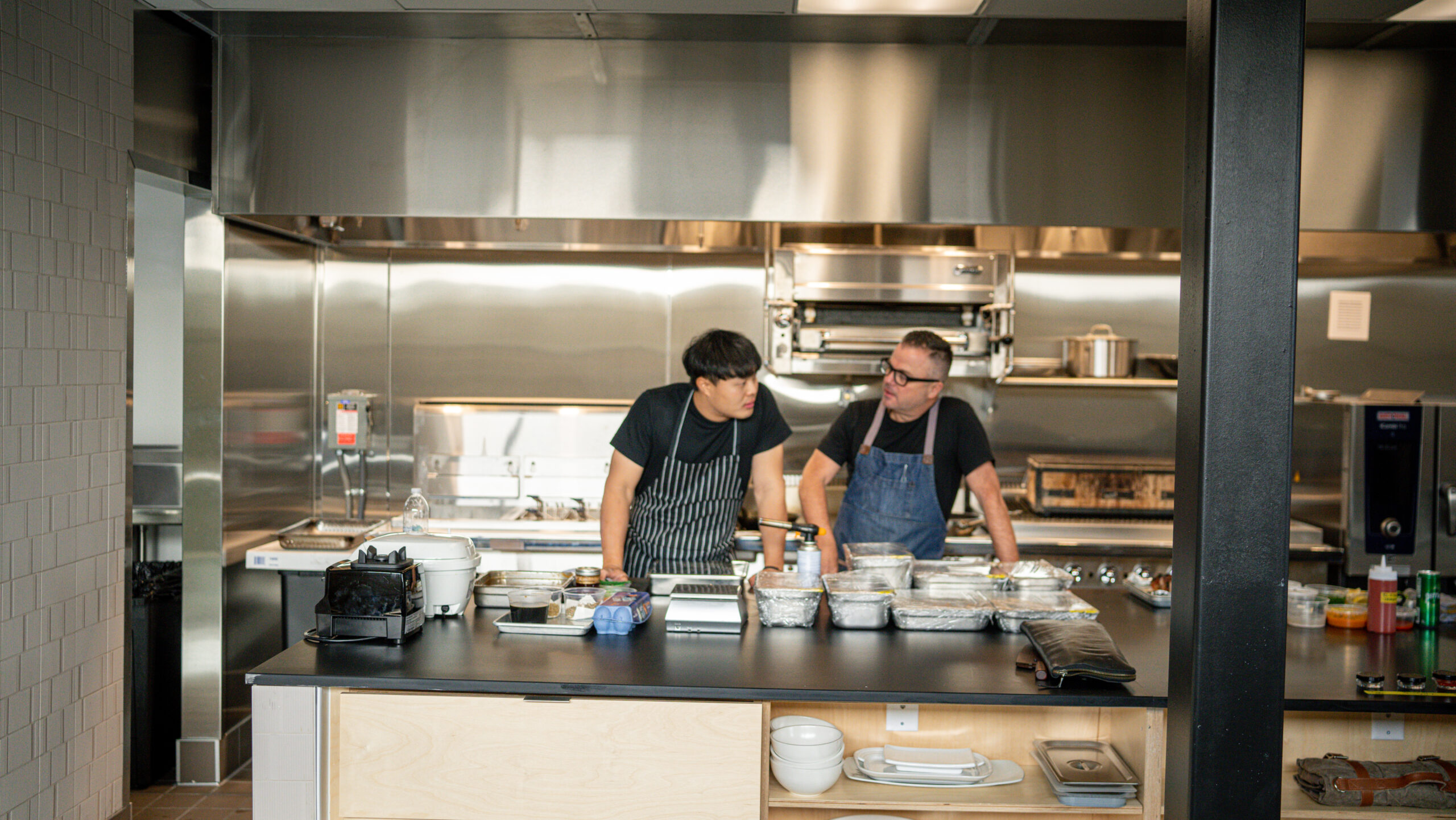 two men in a shiny kitchen