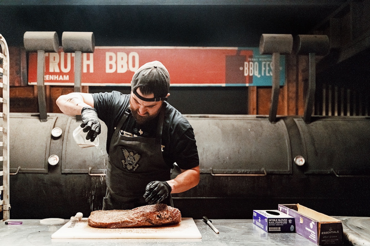 Pitmaster Leonard Botell tends to a brisket at Truth BBQ. | Photo by Truth BBQ
