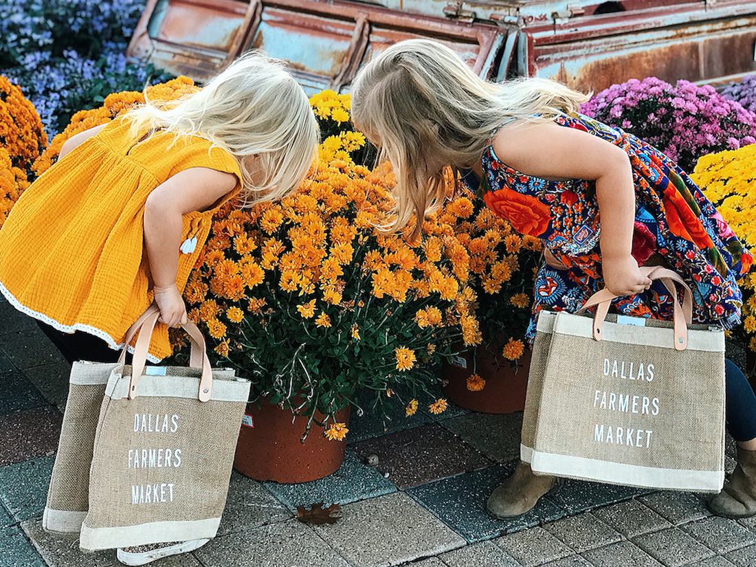 Young shoppers stop and smell the flowers at Dallas Farmers Market. | Photo by Ashley Andrews