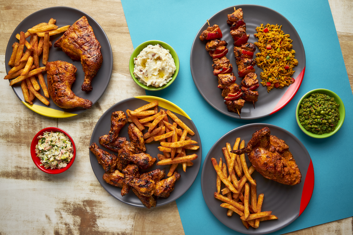 A spread of flame-grilled chicken dishes and sides at Nando's. | Photo by Nando's