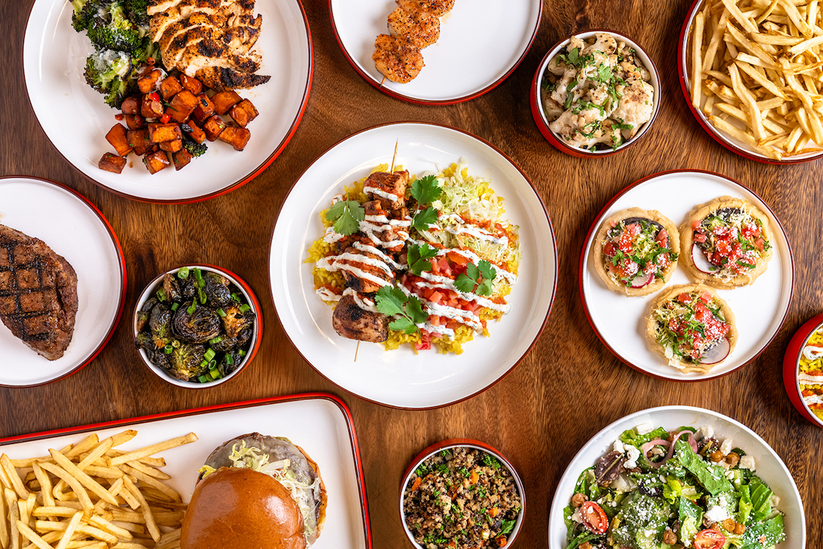 A spread of salads, handhelds, and mains at HG Sply Co. | Photo by UNCO Hospitality