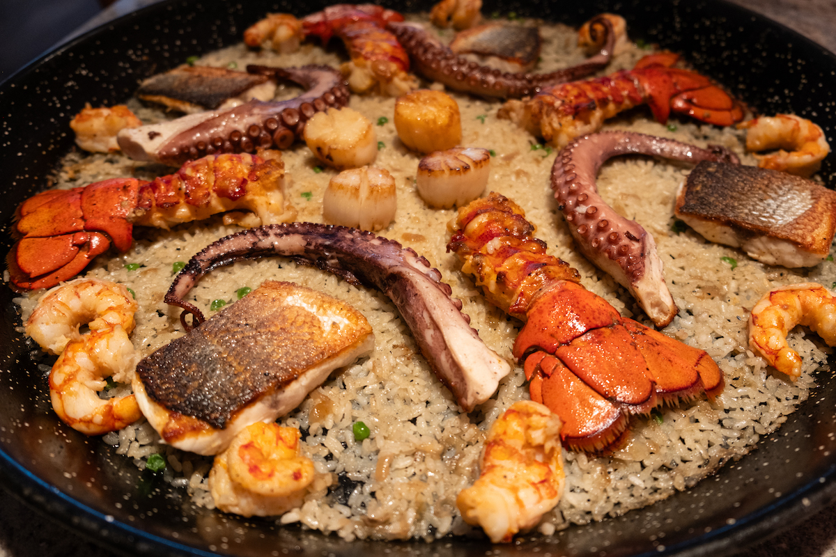 The ultimate seafood paella at MAD combines scallops, lobster tails, shrimp, octopus, and branzino. | Photo by MAD