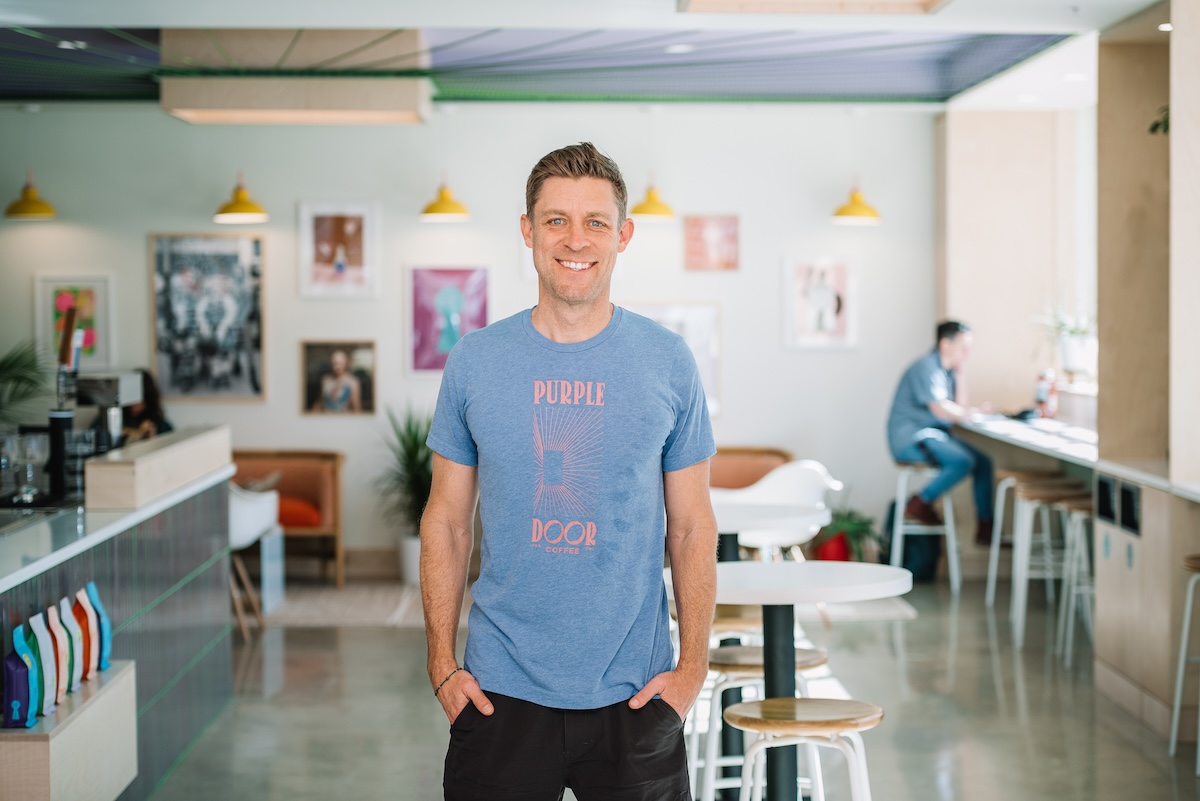 white man in blue shirt standing in light room
