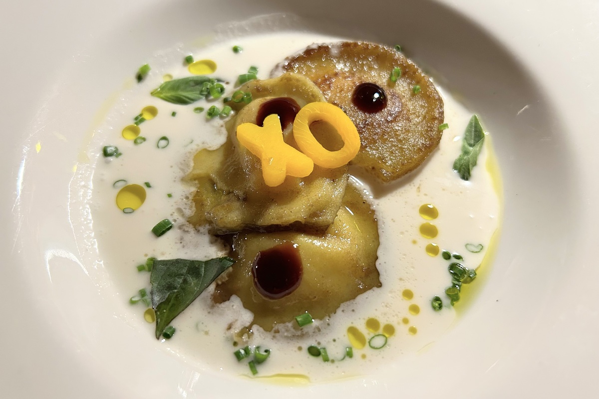 Elegant XO ravioli at Mother Tongue in Denver, served in a creamy sauce with herbs, crispy garnish, and decorative carrot letters for a playful, upscale touch.
