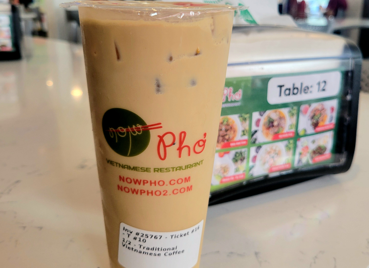 - DiningOut large cup of brown liquid coffee with pho written on it