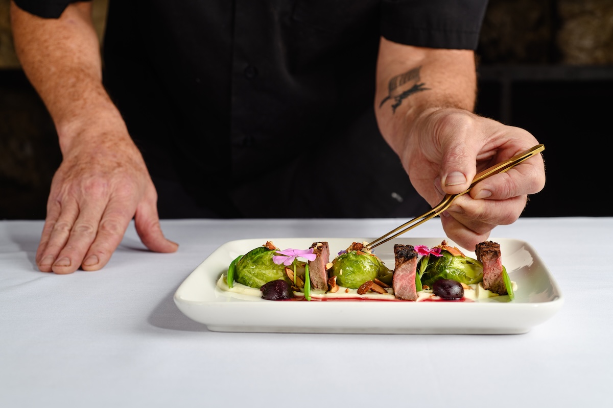 Rare-Houston-people - DiningOut Chef Rand Packer plating a dish at his fine-dining restaurant in Evergreen. | Photo by Evoke 1923