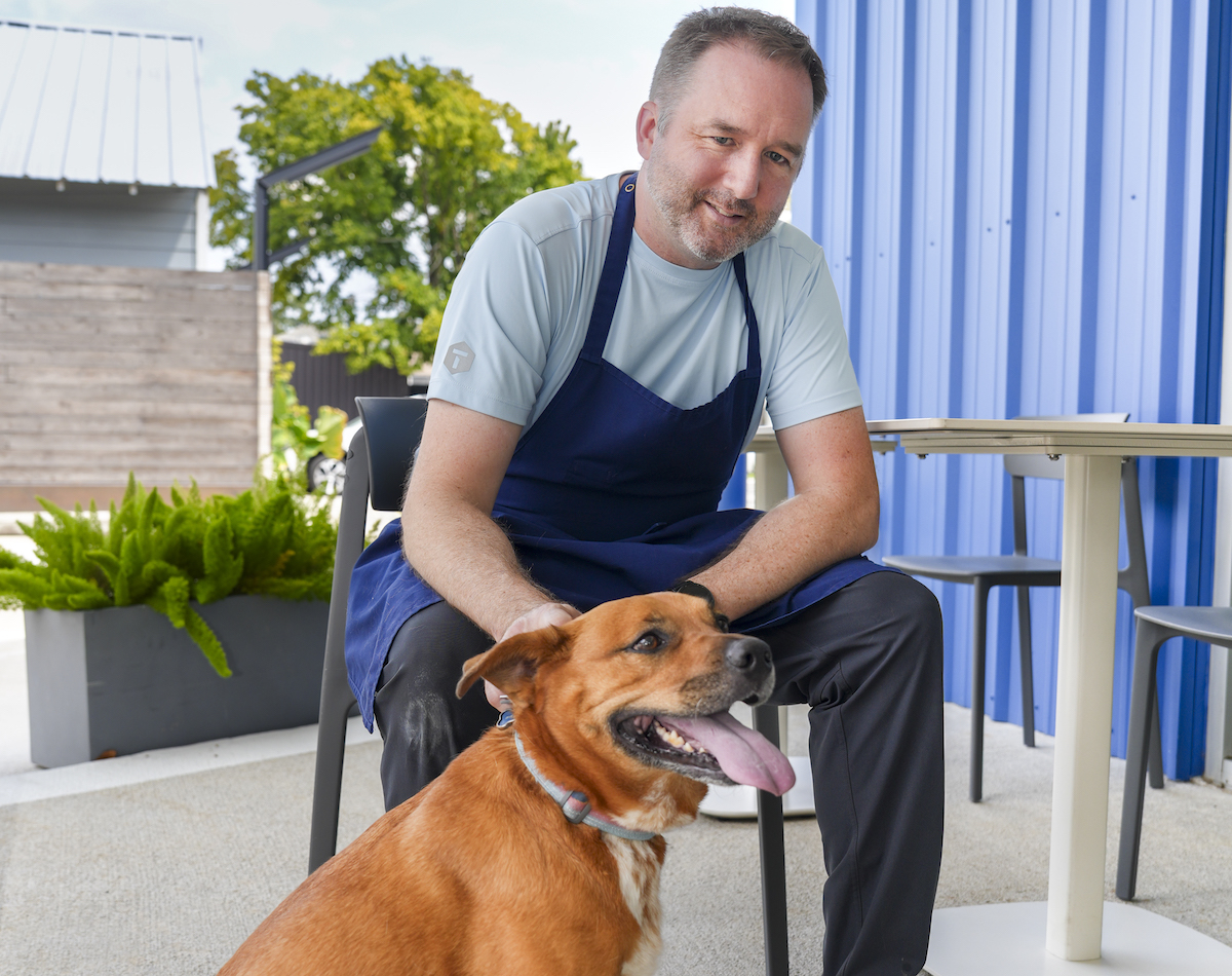Shawn Gawle and his dog Freya, on the patio at Camaraderie. | Photo by Jackie Bayes Media