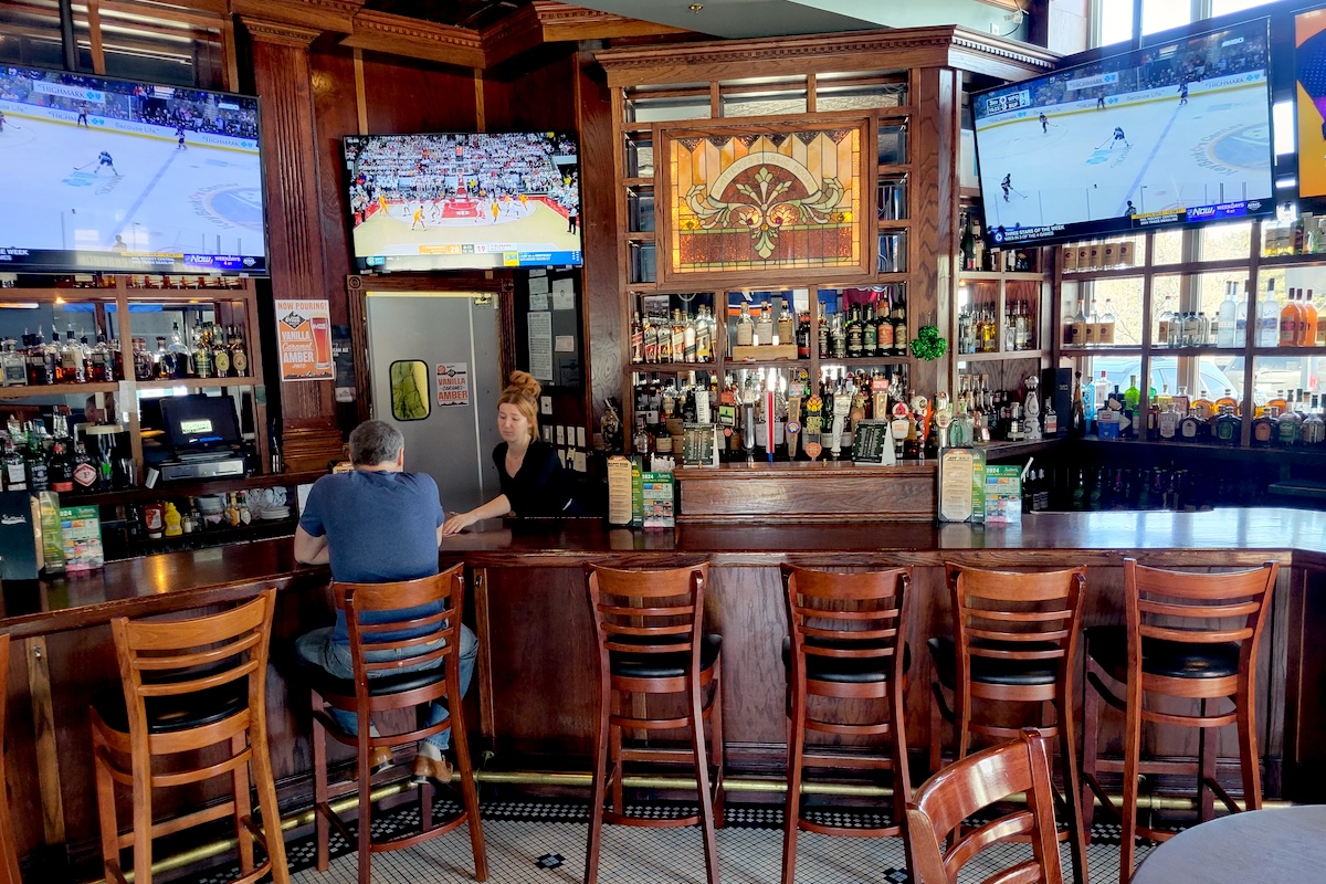 - DiningOut Global wood bar with wood bar stools and lots of liquor bottles