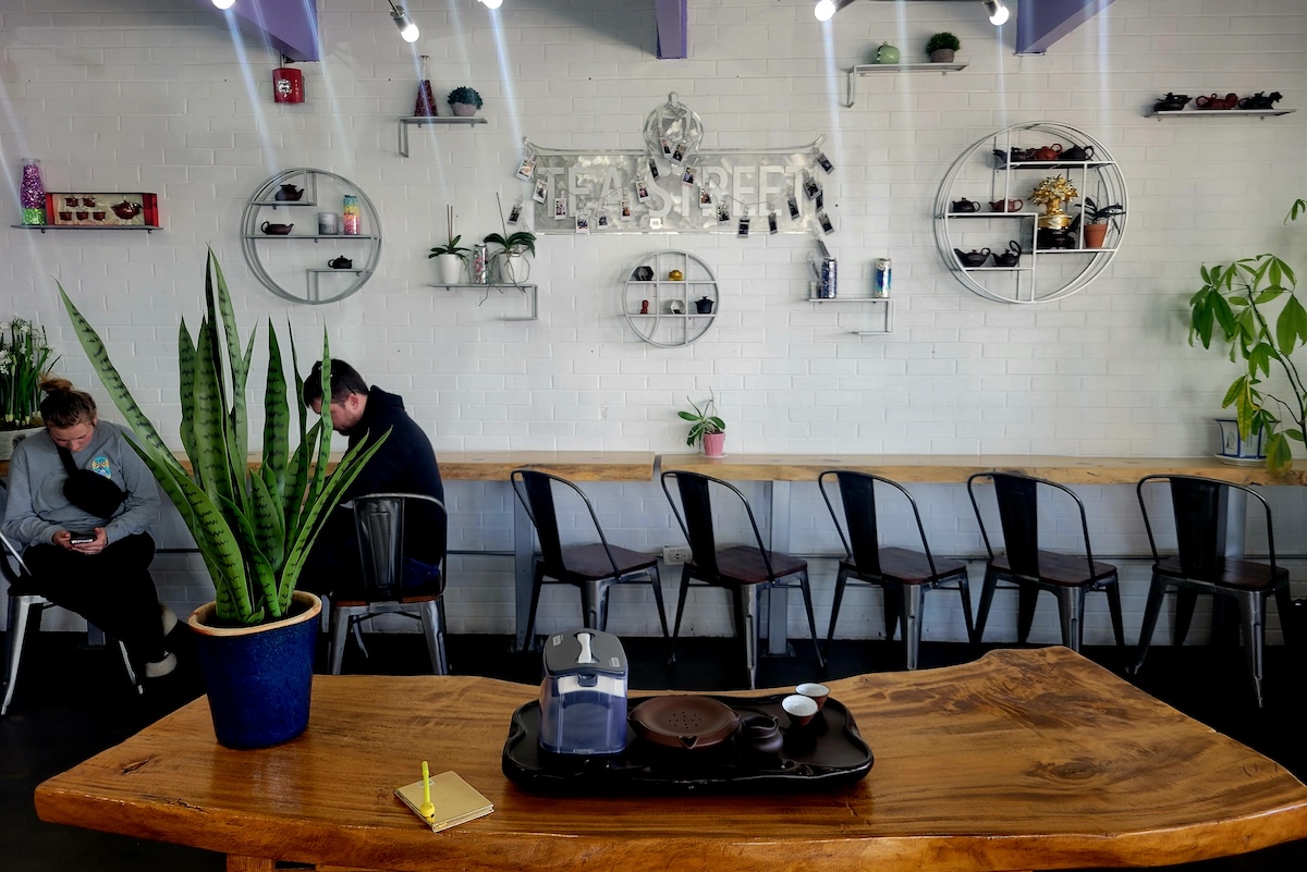 white wall with decorations and black chairs in front