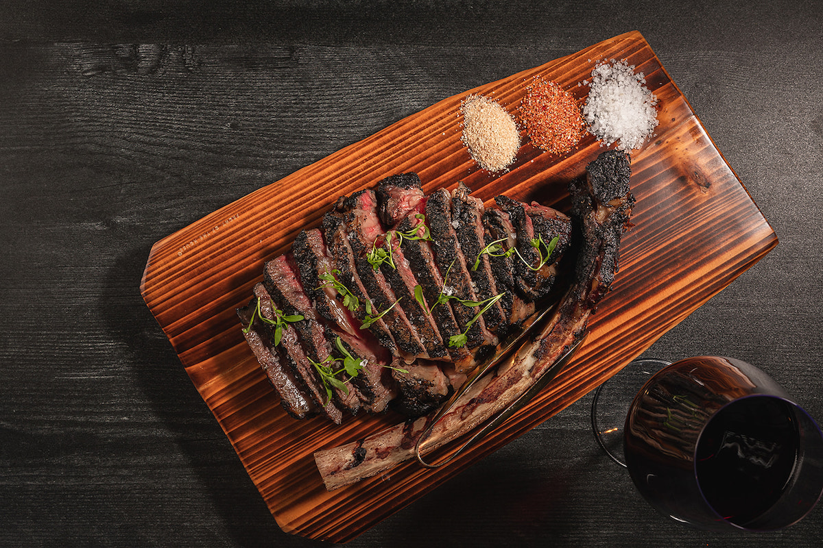 Toca Madera’s showy Flaming Tomahawk entrée is an American Wagyu Tomahawk steak treated in showmanship fashion at tableside for 5. | Photo by Toca Madera